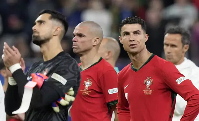 Portugal's goalkeeper Diogo Costa, Pepe and Cristiano Ronaldo, from left, react after losing a quarter final match between Portugal and France at the Euro 2024 soccer tournament in Hamburg, Germany, Friday, July 5, 2024. France won a penalty shoot out 4-3 after the match ended in a 0-0 draw. (AP Photo/Martin Meissner)