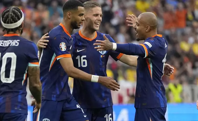 Donyell Malen of the Netherlands, right, is congratulated after scoring his side's 2nd goal during a round of sixteen match between Romania and the Netherlands at the Euro 2024 soccer tournament in Munich, Germany, Tuesday, July 2, 2024. (AP Photo/Matthias Schrader)