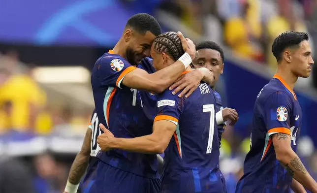 Cody Gakpo of the Netherlands, left, celebrates with Xavi Simons after scoring the opening goal during a round of sixteen match between Romania and the Netherlands at the Euro 2024 soccer tournament in Munich, Germany, Tuesday, July 2, 2024. (AP Photo/Manu Fernandez)