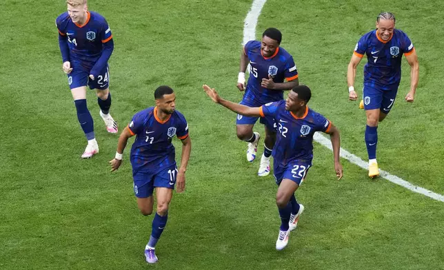 Cody Gakpo of the Netherlands, bottom left, celebrates with teammates after scoring the opening goal during a round of sixteen match between Romania and the Netherlands at the Euro 2024 soccer tournament in Munich, Germany, Tuesday, July 2, 2024. (AP Photo/Frank Augstein)