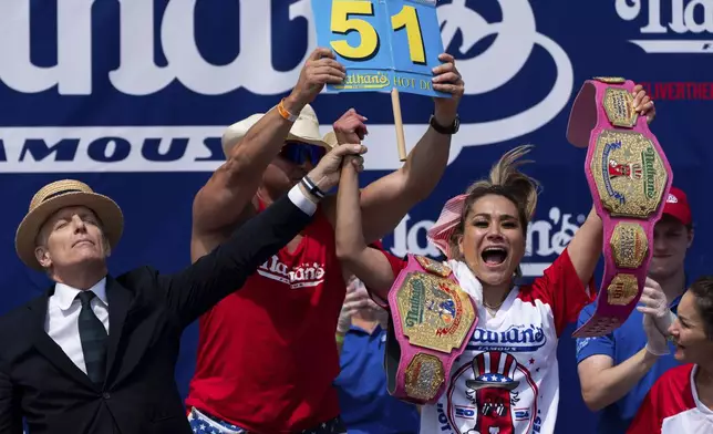 Miki Sudo, right, reacts after winning the women's division in the Nathan's Famous Fourth of July hot dog eating contest, Thursday, July 4, 2024, at Coney Island in the Brooklyn borough of New York. Sudo ate a record 51 hot dogs. (AP Photo/Julia Nikhinson)