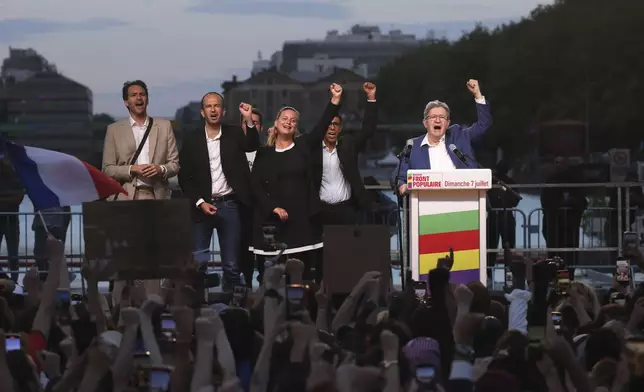 Far-left La France Insoumise - LFI - (France Unbowed) founder Jean-Luc Melenchon, right, clenches his fist with other party members after the second round of the legislative elections Sunday, July 7, 2024, in Paris. A coalition on the left that came together unexpectedly ahead of France's snap elections won the most parliamentary seats in the vote, according to polling projections Sunday. The surprise projections put President Emmanuel Macron's centrist alliance in second and the far right in third. (AP Photo/Thomas Padilla)