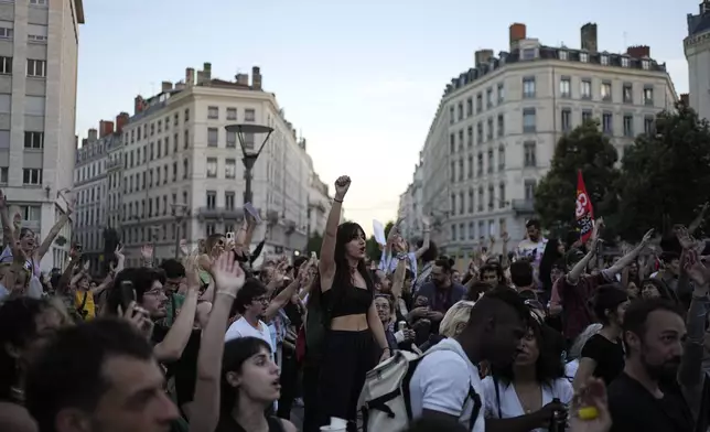 People stand in a square as they react to projected results after the second round of the legislative elections, in Lyon, central France, Sunday, July 7, 2024. Polls have closed in France, and polling projections say a coalition on the left that came together unexpectedly has won the most parliamentary seats in the pivotal runoff elections after a high turnout among voters. (AP Photo/Laurent Cipriani)