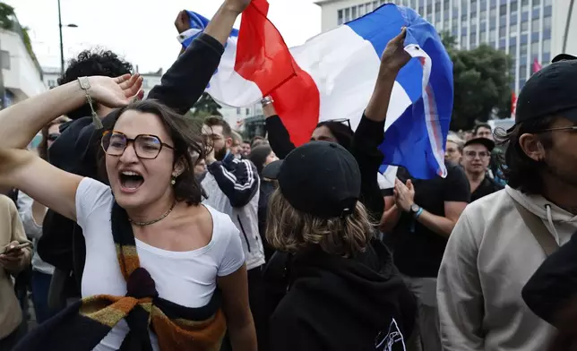 People wave French flags as they react to projected results after the second round of the legislative elections, Sunday, July 7, 2024, in Nantes, western France. Polls have closed in France, and polling projections say a coalition on the left that came together unexpectedly has won the most parliamentary seats in the pivotal runoff elections after a high turnout among voters. (AP Photo/Jeremias Gonzalez)