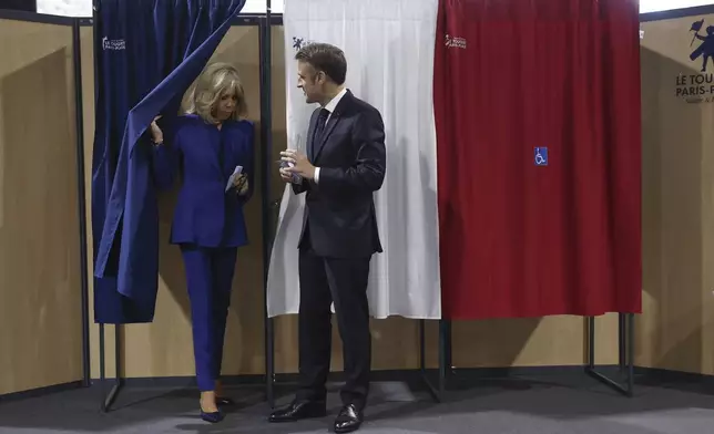 French President Emmanuel Macron and his wife Brigitte Macron leave the voting booth before voting for the second round of the legislative elections in Le Touquet-Paris-Plage, northern France, Sunday July 7 2024. Voting has begun in mainland France on Sunday in pivotal runoff elections that could hand a historic victory to Marine Le Pen's far-right National Rally and its inward-looking, anti-immigrant vision — or produce a hung parliament and political deadlock. (Mohammed Badra, Pool via AP)