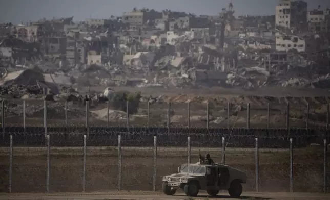 Israeli soldiers move near the Israeli-Gaza border, as seen from southern Israel, Monday, July 8, 2024. Israeli forces advanced deeper into the Gaza Strip's largest city in pursuit of militants who had regrouped there, sending thousands of Palestinians fleeing on Monday from an area ravaged in the early weeks of the nine-month-long war. (AP Photo/Leo Correa)