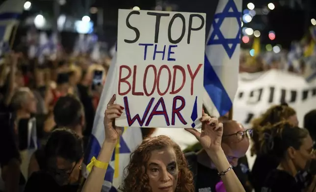 A demonstrator holds a sign during a protest marking nine months since the start of the war and calling for the release of hostages held in the Gaza Strip by the Hamas militant group, in Tel Aviv, Israel, Sunday, July 7, 2024. (AP Photo/Leo Correa)