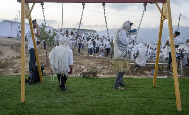 Jewish settlers pray in the Eviatar outpost in the Israeli-occupied West Bank during morning prayers calling for the legalization of the outpost and the return of the hostages held in the Gaza Strip by the Hamas militant group, Sunday, July 7, 2024. Far-right ministers in Israel’s government have said they want to legalize unauthorized outposts in the West Bank in a sweeping expansion of settlements. (AP Photo/Ohad Zwigenberg)