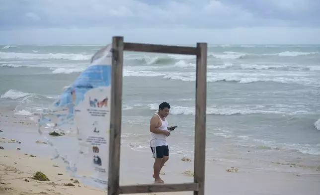 A man walks on the beach in the aftermath of Hurricane Beryl in Tulum, Mexico, Friday, July 5, 2024. (AP Photo/Fernando Llano)