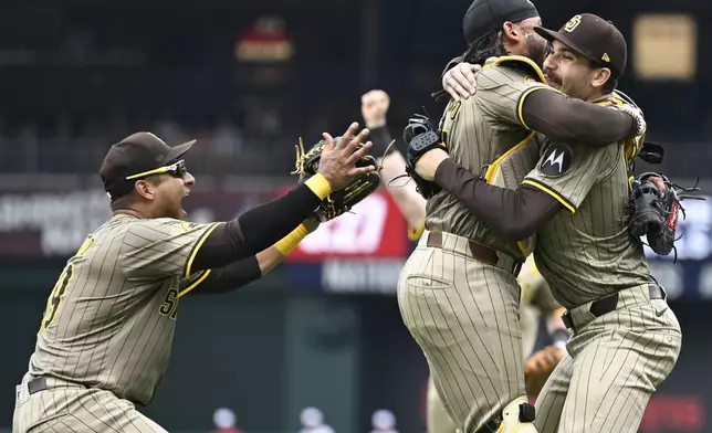 San Diego Padres third baseman Donovan Solano, left, joins in the celebration with catcher Luis Campusano and starting pitcher Dylan Cease, right, after Cease tossed no-hitter in a baseball game against the Washington Nationals, Thursday, July 25, 2024, in Washington. (AP Photo/John McDonnell)