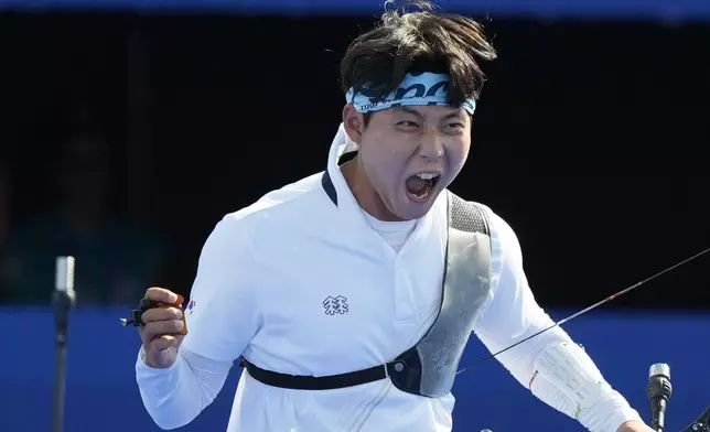 South Korea's Wooseok Lee celebrates with after a win during the men's team gold medal match Archery competition against France at the 2024 Summer Olympics, Monday, July 29, 2024, in Paris, France. (AP Photo/Rebecca Blackwell)