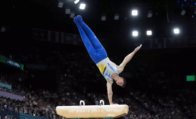 Illia Kovtun, of Ukraine, performs on the pommel horse during the men's artistic gymnastics team finals round at Bercy Arena at the 2024 Summer Olympics, Monday, July 29, 2024, in Paris, France. (AP Photo/Charlie Riedel)