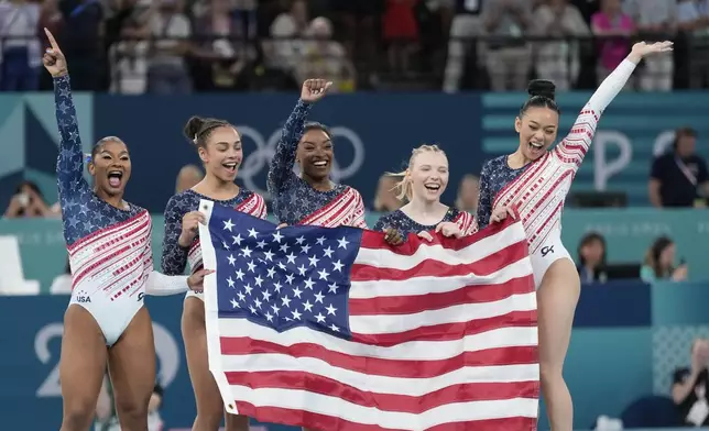 Members of Team USA celebrate after winning the gold medal in the women's artistic gymnastics team finals round at Bercy Arena at the 2024 Summer Olympics, Tuesday, July 30, 2024, in Paris, France. (AP Photo/Natacha Pisarenko)