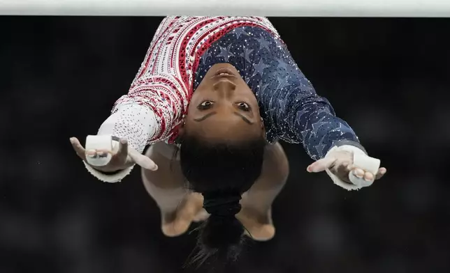 Simone Biles, of the United States, performs on the uneven bars during the women's artistic gymnastics team finals round at Bercy Arena at the 2024 Summer Olympics, Tuesday, July 30, 2024, in Paris, France. (AP Photo/Natacha Pisarenko)