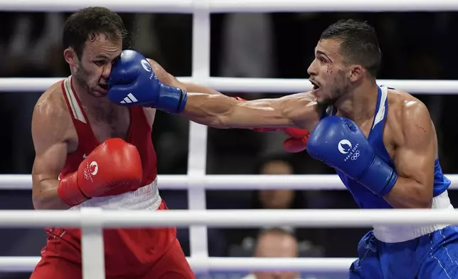 Bulgaria's Radoslav Rosenov lands a right to Tajikistan's Bakhodur Usmonov in their men's 63.5 kg preliminary boxing match at the 2024 Summer Olympics, Saturday, July 27, 2024, in Paris, France. (AP Photo/John Locher)