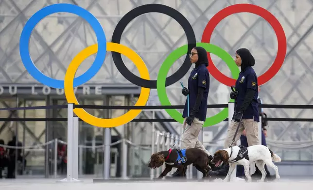 Members of the United Arab Emirates security team patrol a square near the Louvre in Paris, France, ahead of the opening ceremony of the 2024 Summer Olympics, Friday, July 26, 2024. (AP Photo/Ebrahim Noroozi)