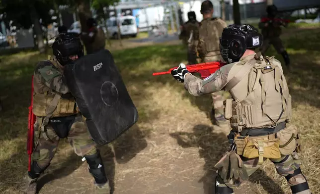 Soldiers demonstrate operational technics for close combat in a training class at a military camp set up for the Paris Olympic games Friday, July 19, 2024, Vincennes, just outside Paris, France. (AP Photo/David Goldman)