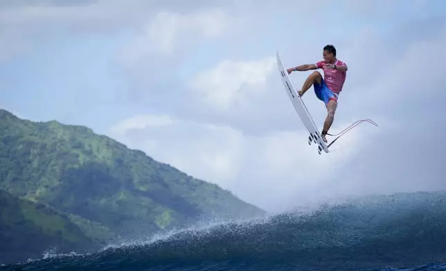 Kauli Vaast, of France, leaps over a wave during the second round of the 2024 Summer Olympics surfing competition Sunday, July 28, 2024, in Teahupo'o, Tahiti. (AP Photo/Gregory Bull)