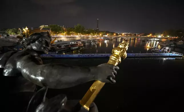 Technicians remove the pontoon for the start of the triathlon events after the event was postponed over concerns about water quality in Paris' Seine River, at the 2024 Summer Olympics, Tuesday, July 30, 2024, at the Pont Alexandre III bridge in Paris, France. (AP Photo/Vadim Ghirda)