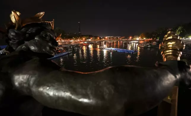 Technicians remove the pontoon for the start of the triathlon events after the event was postponed over concerns about water quality in Paris' Seine River, at the 2024 Summer Olympics, Tuesday, July 30, 2024, at the Pont Alexandre III bridge in Paris, France. (AP Photo/Vadim Ghirda)