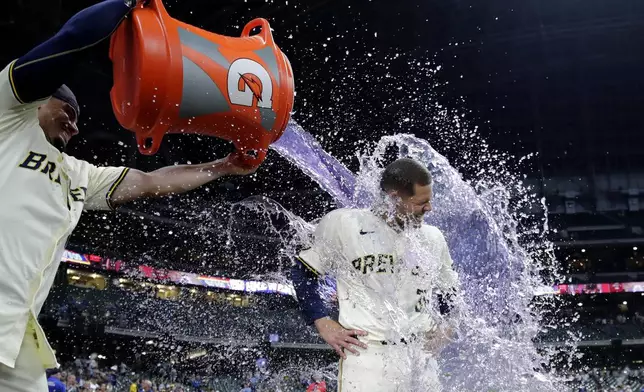 Milwaukee Brewers' Tobias Myers, right, gets doused with liquid by Willy Adames (27) after a baseball game against the Pittsburgh Pirates, Wednesday, July 10, 2024, in Milwaukee. (AP Photo/Aaron Gash)