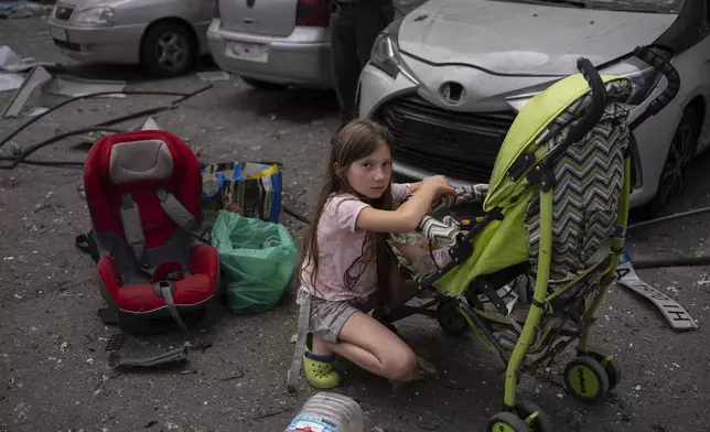 Polina, 10, looks after her sister Marina, 3, at the site of Okhmatdyt children's hospital hit by Russian missiles, in Kyiv, Ukraine, Monday, July 8, 2024. A major Russian missile attack across Ukraine on Monday killed at least 31 people and injured 154, officials said, with one striking a large children’s hospital in the capital of Kyiv, where emergency crews searched the rubble for victims. (AP Photo/Alex Babenko)(AP Photo/Alex Babenko)