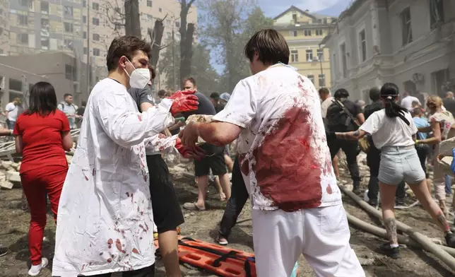 Rescuers, medical staff and volunteers clean up the rubble and search victims after Russian missile hit the country's main children hospital Okhmadit in Kyiv, Ukraine, Monday, July 8, 2024. The daytime barrage targeted five Ukrainian cities with more than 40 missiles of different types hitting apartment buildings and public infrastructure, President Volodymyr Zelenskyy said on social media. (AP Photo/Anton Shtuka)