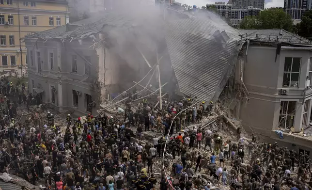 Emergency workers respond at the Okhmatdyt children's hospital hit by Russian missiles, in Kyiv, Ukraine, Monday, July 8, 2024. A major Russian missile attack across Ukraine on Monday killed at least 31 people and injured 154, officials said, with one striking a large children’s hospital in the capital of Kyiv, where emergency crews searched the rubble for victims. (AP Photo/Alex Babenko)