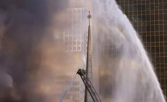 The First Baptist Dallas church's steeple stands as firefighters battle a fire at the church Friday, July 19, 2024, in Dallas. (Chitose Suzuki/The Dallas Morning News via AP)