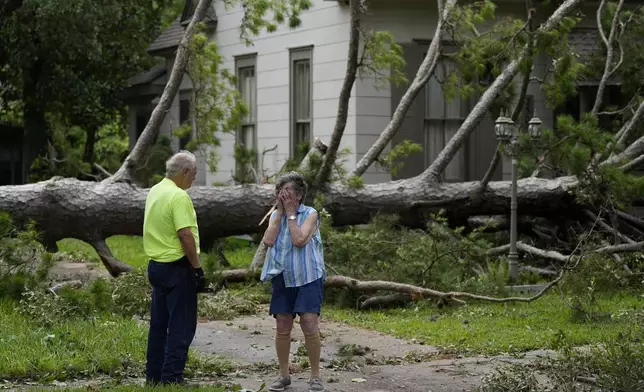 Jackie Jecmenek, right, talks with city worker Bobby Head as she stands in front of her neighbor's home after Beryl passed, Monday, July 8, 2024, in Bay City, Texas. (AP Photo/Eric Gay)