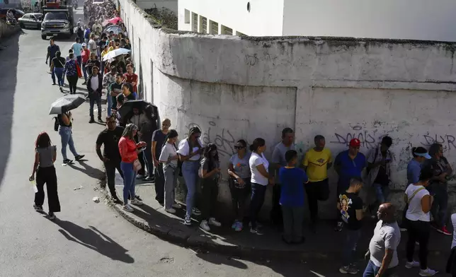 Voters line up outside a polling station during the presidential election in Caracas, Venezuela, Sunday, July 28, 2024. (AP Photo/Cristian Hernandez)