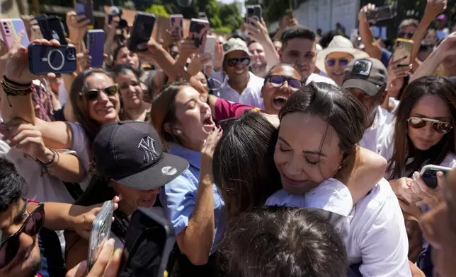 Opposition leader Maria Corina Machado hugs supporters after voting in the presidential election in Caracas, Venezuela, Sunday, July 28, 2024. (AP Photo/Matias Delacroix)