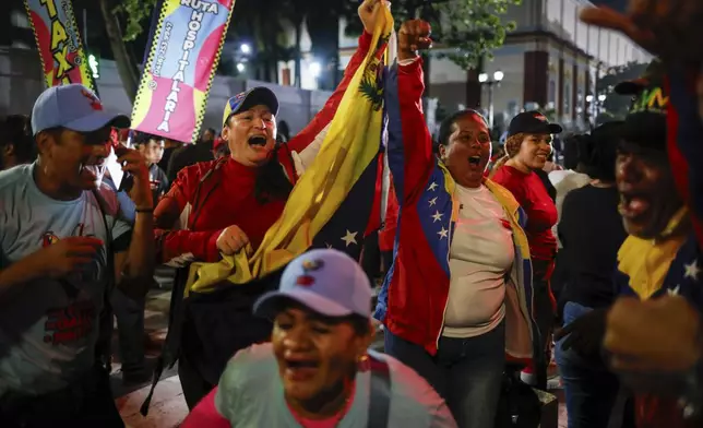 Supporters of President Nicolas Maduro celebrate after electoral authorities declared him the winner of the presidential election in Caracas, Venezuela, Monday, July 29, 2024. (AP Photo/Cristian Hernandez)