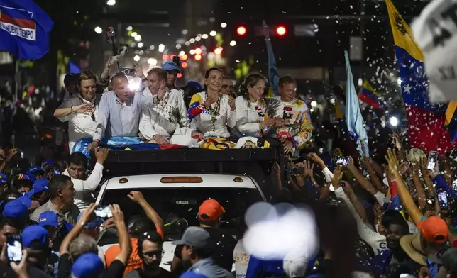 Presidential candidate Edmundo Gonzalez, center left, and opposition leader Maria Corina Machado, center right, greet supporters during a campaign rally in Maracaibo, Venezuela, Tuesday, July 23, 2024. The presidential election is set for July 28. (AP Photo/Matias Delacroix)