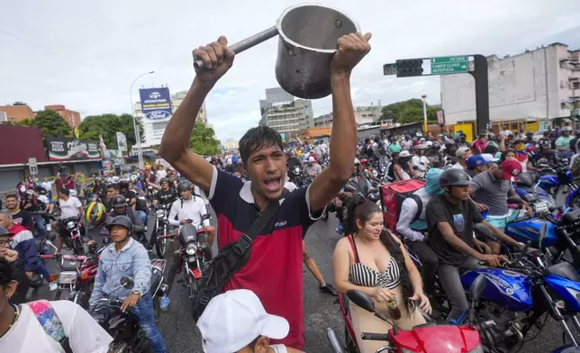 People protest the official election results declaring President Nicolas Maduro the winner of the presidential election, the day after the vote in Caracas, Venezuela, Monday, July 29, 2024. (AP Photo/Fernando Vergara)