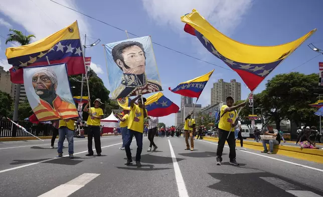 Supporters of Venezuelan President Nicolas Maduro wave Venezuelan flags and posters of national heroes as they arrive early for Maduro's closing election campaign rally in Caracas, Venezuela, Thursday, July 25, 2024. The presidential election is set for July 28. (AP Photo/Fernando Vergara)