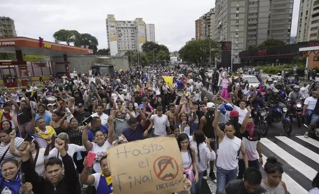 Protesters march against the official election results declaring President Nicolas Maduro the winner, the day after the presidential election in Caracas, Venezuela, Monday, July 29, 2024. The sign reads in Spanish "Until the end. No dictator." (AP Photo/Matias Delacroix)