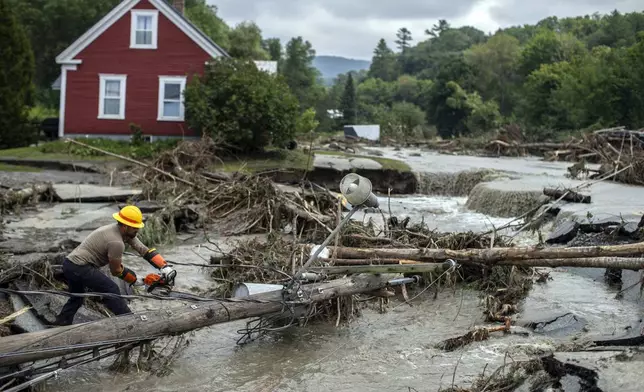 Zac Drown, of Lyndon Electric Company, clears debris amid flood damage in Lyndon, Vt., Tuesday, July 30, 2024. (AP Photo/Dmitry Belyakov)