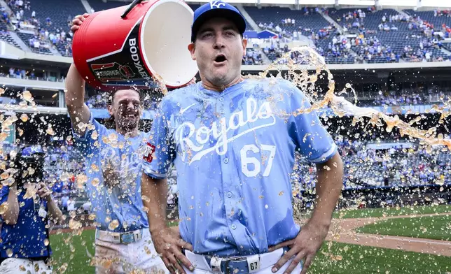 Kansas City Royals starting pitcher Seth Lugo (67) is doused with ice water by Bobby Witt Jr. after pitching a complete game in their win over the Chicago White Sox during a baseball game, Sunday, July 21, 2024, in Kansas City, Mo. (AP Photo/Reed Hoffmann)