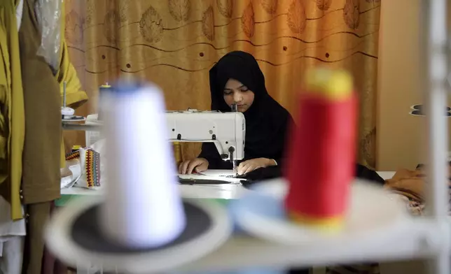 An Afghan woman tailor works with a sewing machine in the Afghan Women Business Hub in Kabul, Afghanistan, Tuesday, July 2, 2024. Half of Afghanistan's population now finds itself locked out of the freedom to work at a time when the country's economy is worse than ever, with few jobs available to women in the country. (AP Photo/Siddiqullah Alizai)