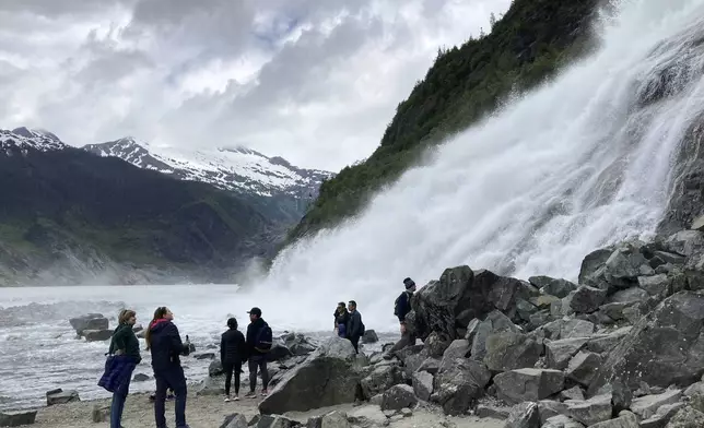 FILE - People gather near the base of Nugget Falls, a popular destination for selfies on June 13, 2023, at the Mendenhall Glacier Recreation Area, in Juneau, Alaska. Voters in Alaska's capital city could decide in October whether to ban large cruise ships on Saturdays starting next year. Supporters of the proposal say it would give residents a reprieve from the crush of tourists drawn to attractions like Juneau's fast-retreating Mendenhall Glacier, but opponents say it would hurt local businesses and invite lawsuits. (AP Photo/Becky Bohrer, File)