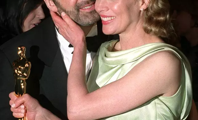 FILE - Holding her Oscar, Kim Basinger embraces her husband Alec Baldwin at a post Academy Awards party at Morton's restaurant in West Hollywood, Calif., March 24, 1998. Basinger won the Oscar for Best Supporting Actress for her performance in "L.A. Confidential." (AP Photo/Rene Macura, File)