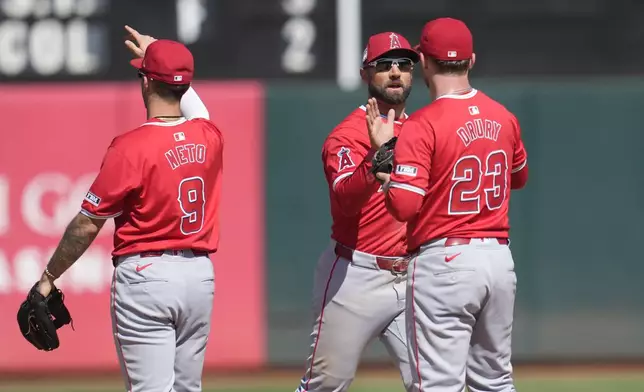 Los Angeles Angels shortstop Zach Neto (9) celebrates with center fielder Kevin Pillar, center, and first baseman Brandon Drury (23) after they defeated the Oakland Athletics in a baseball game in Oakland, Calif., Sunday, July 21, 2024. (AP Photo/Jeff Chiu)