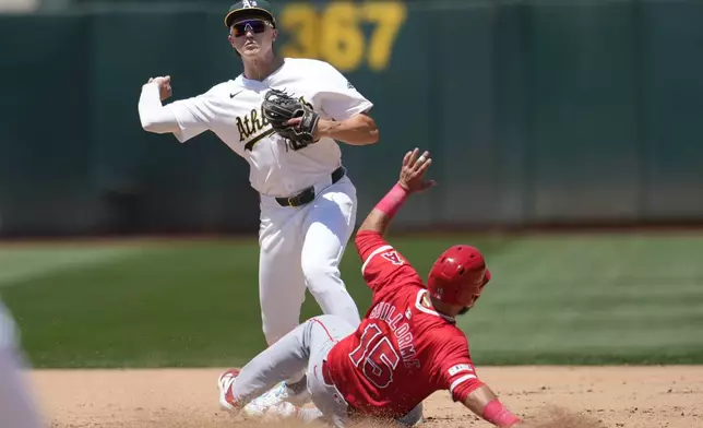 Oakland Athletics second baseman Zack Gelof, top, throws to first base after forcing Los Angeles Angels' Luis Guillorme (15) out at second base on a double play hit into by Anthony Rendon during the fifth inning of a baseball game in Oakland, Calif., Saturday, July 20, 2024. (AP Photo/Jeff Chiu)