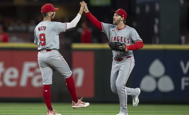 Los Angeles Angels' Zach Neto, left, and Taylor Ward celebrate after a baseball game against the Seattle Mariners, Tuesday, July 23, 2024, in Seattle. (AP Photo/Stephen Brashear)