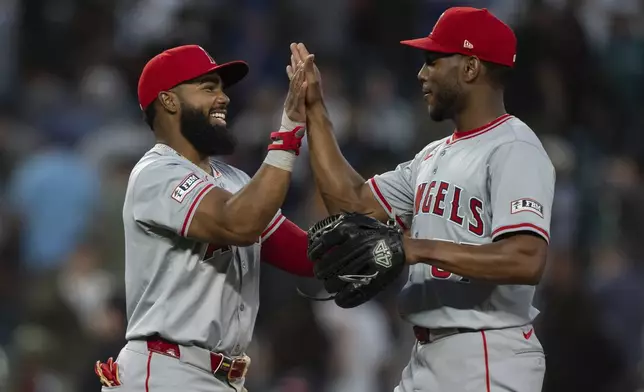 Los Angeles Angels' Luis Rengifo, left, and Roansy Contreras celebrate after a baseball game against the Seattle Mariners, Tuesday, July 23, 2024, in Seattle. (AP Photo/Stephen Brashear)