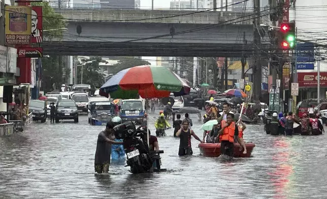 Streets flood from monsoon rains worsened by offshore typhoon Gaemi on Wednesday, July 24, 2024, in Manila, Philippines. (AP Photo/Joeal Capulitan)