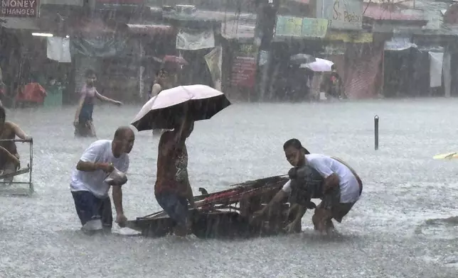 Streets flood from monsoon rains worsened by offshore typhoon Gaemi on Wednesday, July 24, 2024, in Manila, Philippines. (AP Photo/Joeal Capulitan)