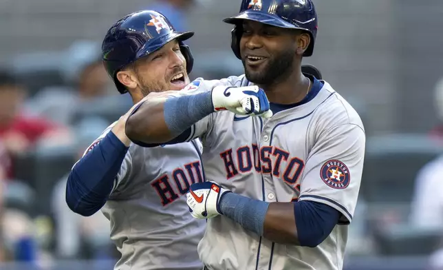 Houston Astros designated hitter Yordan Alvarez, right, is congratulated by teammate Alex Bregman, left, after they scored on his two-run home run against the Toronto Blue Jaysi n ninth-inning baseball game action in Toronto, Monday, July 1, 2024. (Frank Gunn/The Canadian Press via AP)