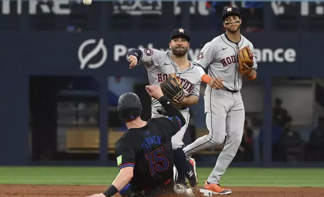 Houston Astros second baseman Jose Altuve, center, forces out Toronto Blue Jays' Brian Serven (15) and throws to first base to complete the double play during the fifth inning of a baseball game in Toronto on Wednesday, July 3, 2024. (Jon Blacker/The Canadian Press via AP)